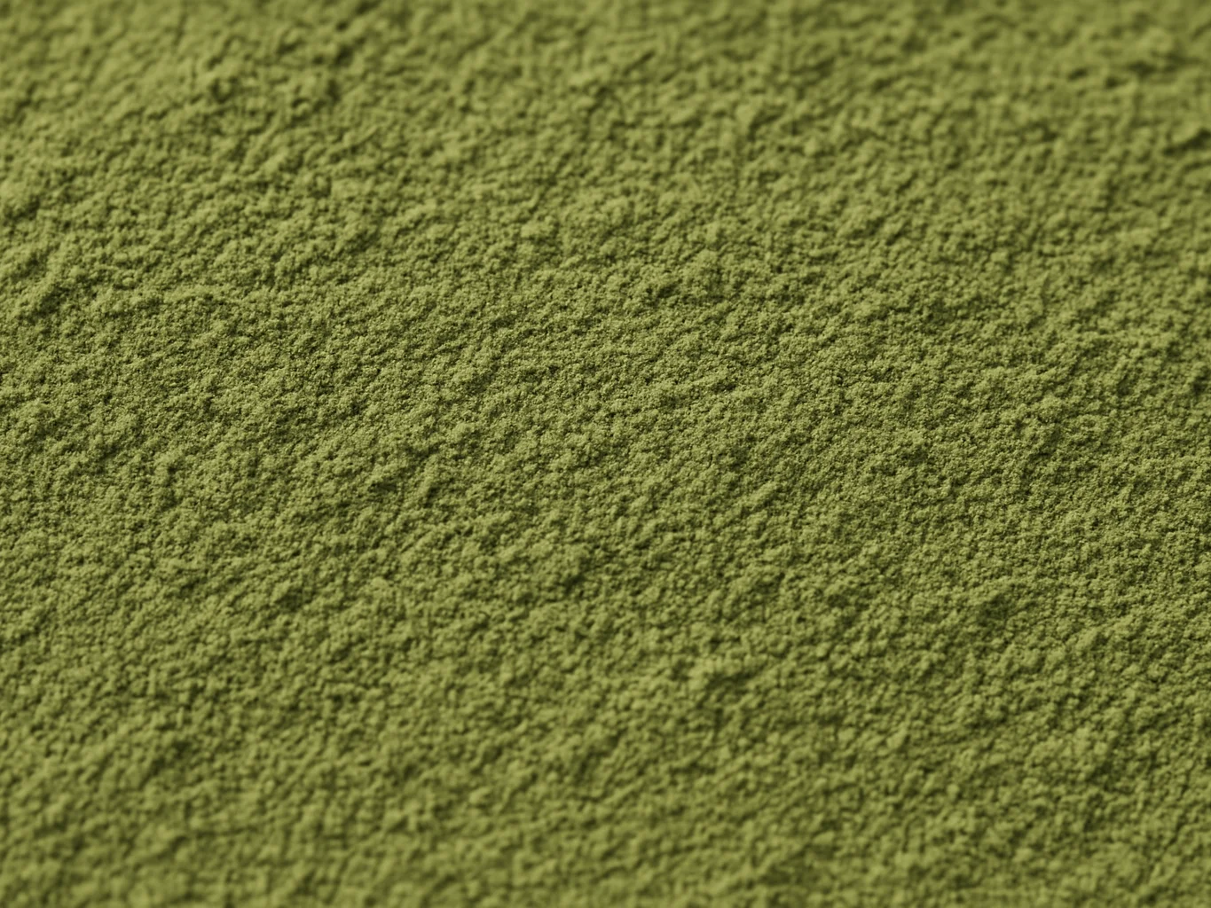 Fine sifted green hina powder texture under neutral natural daylight, macro close-up showing micro-particle fineness